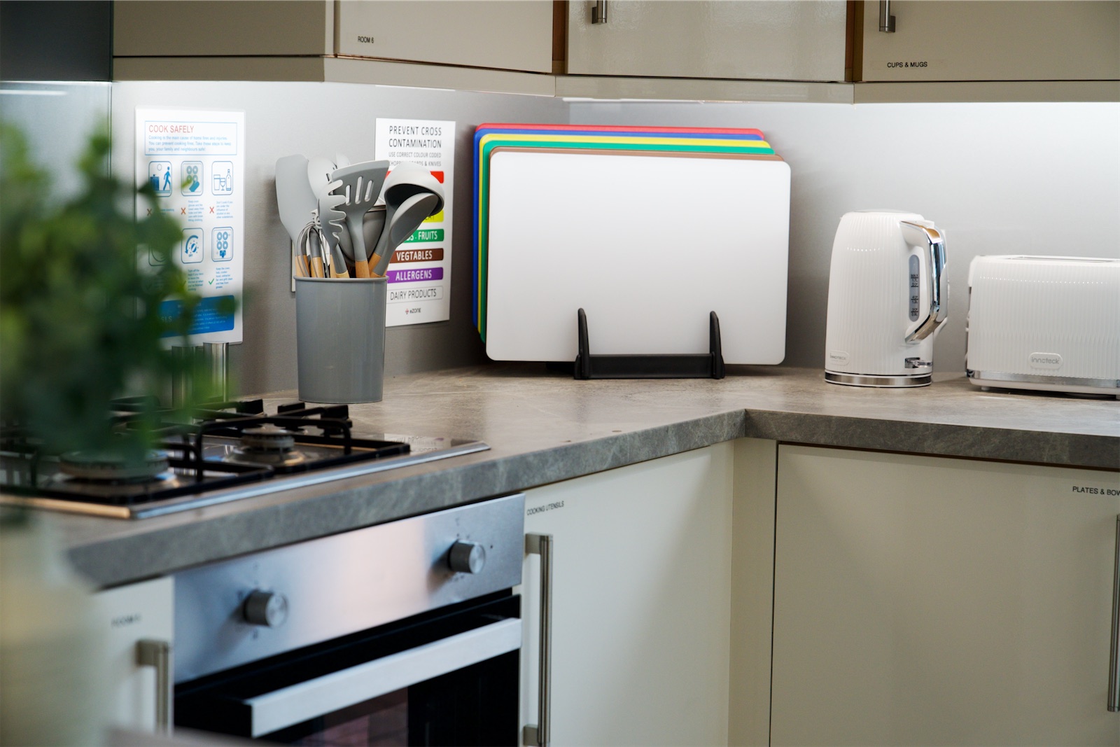 Eden House kitchen with colour-coded chopping boards, utensils and cooking safety guidance.